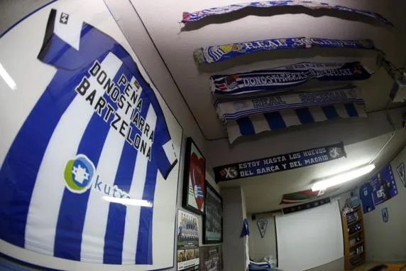 Camiseta enmarcada y bufandas de la Real Sociedad en el local de la Peña Donostiarras Bartzelona