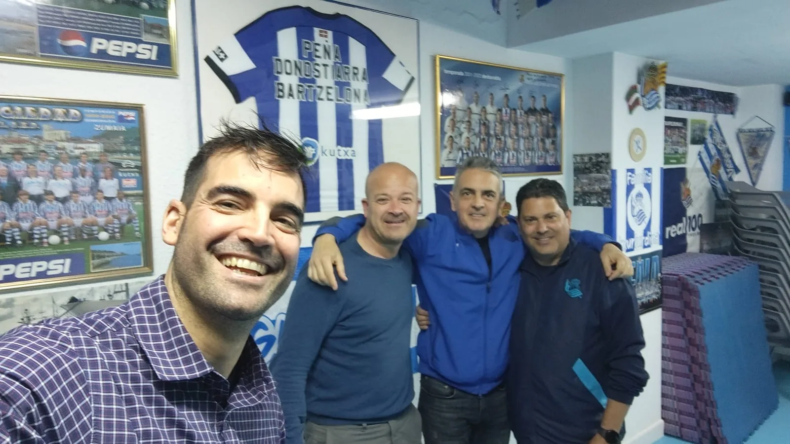 Socios de la peña en su local, con la camiseta enmarcada Peña Donostiarra Bartzelona y recuerdos en las paredes