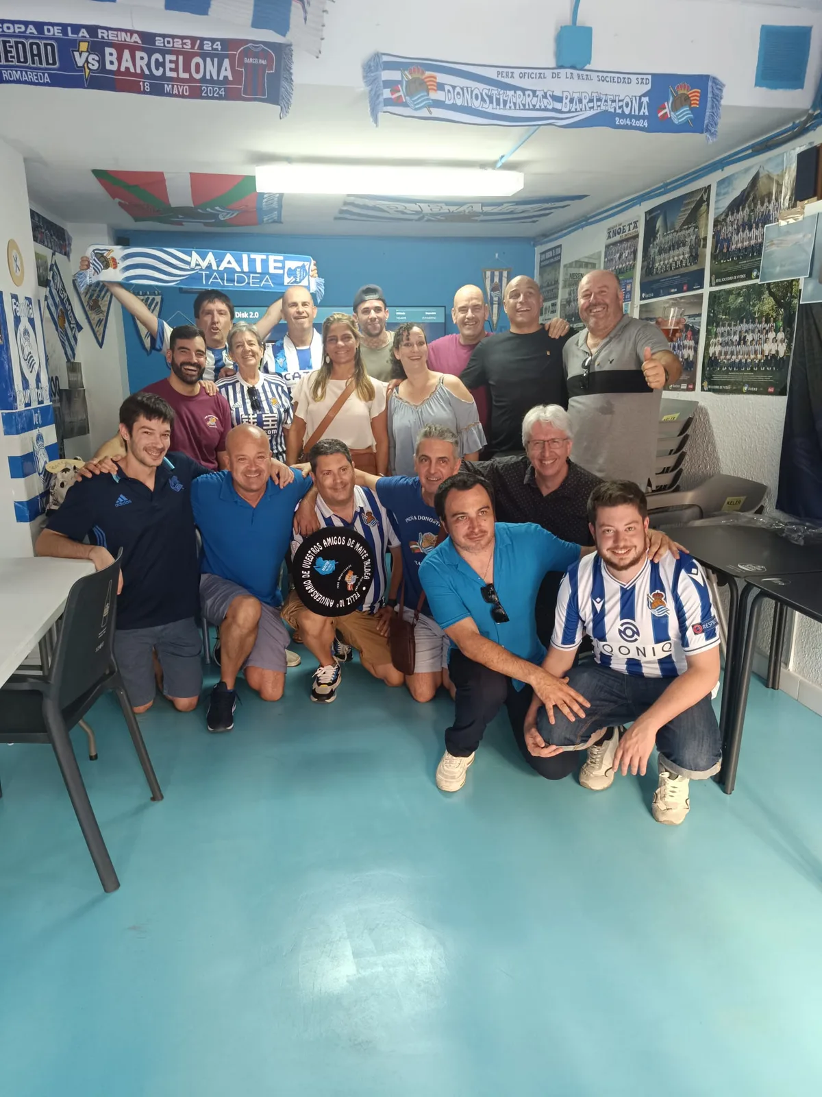 Socios de la peña en su local decorado con bufandas conmemorativas del 10º aniversario y banderines