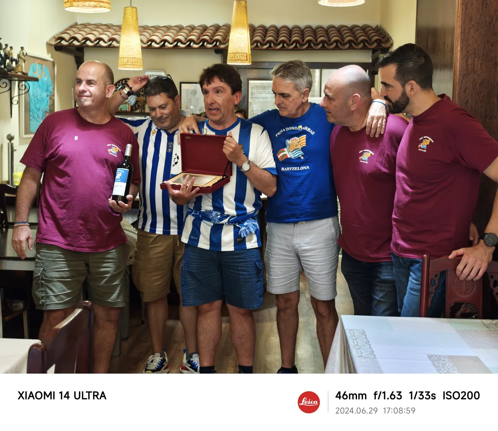 Socios en un restaurante mostrando una placa conmemorativa durante la celebración del 10º aniversario