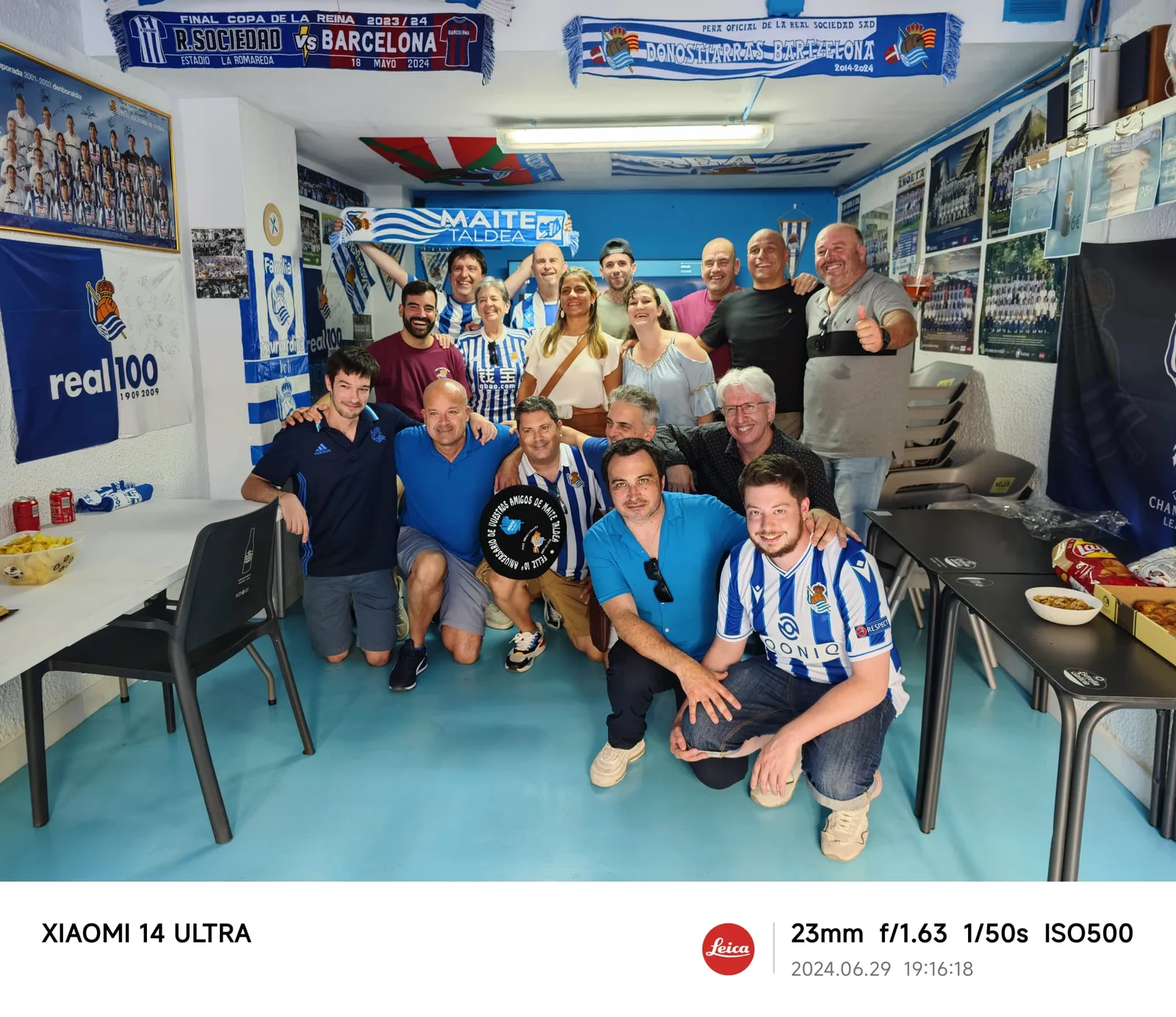 Grupo numeroso de socios en el local de la peña con banderas conmemorativas del 10º aniversario