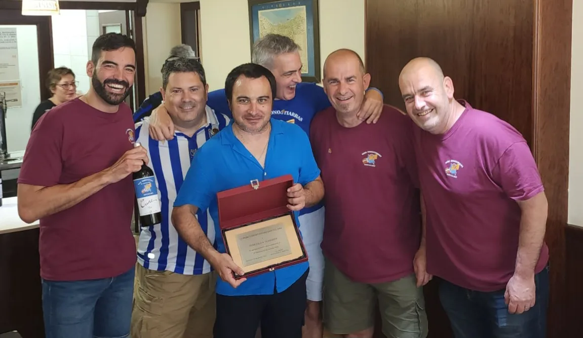 Socios en un restaurante mostrando una placa conmemorativa enmarcada del aniversario