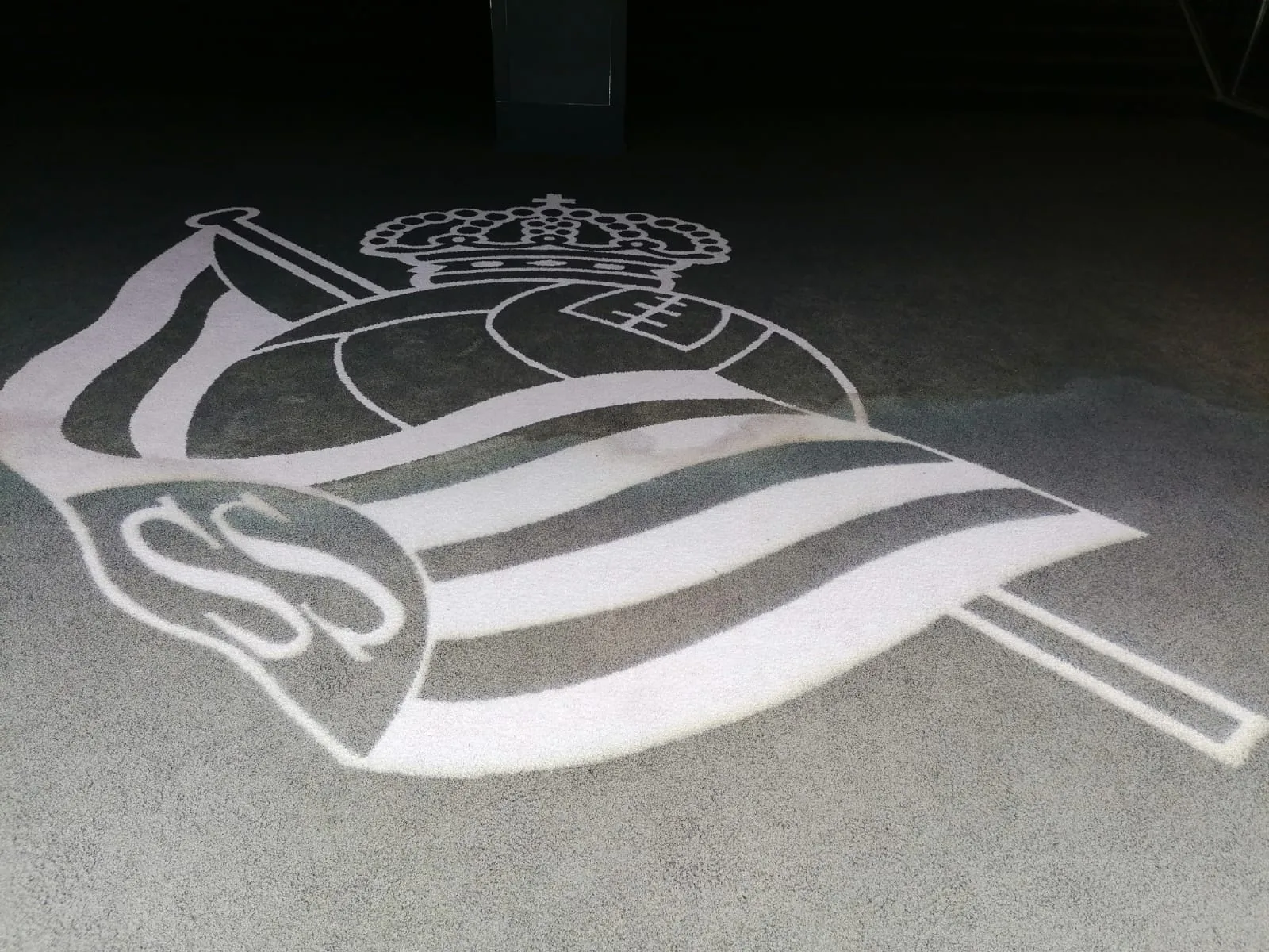 Escudo de la Real Sociedad estampado en el suelo de un pasillo del Reale Arena