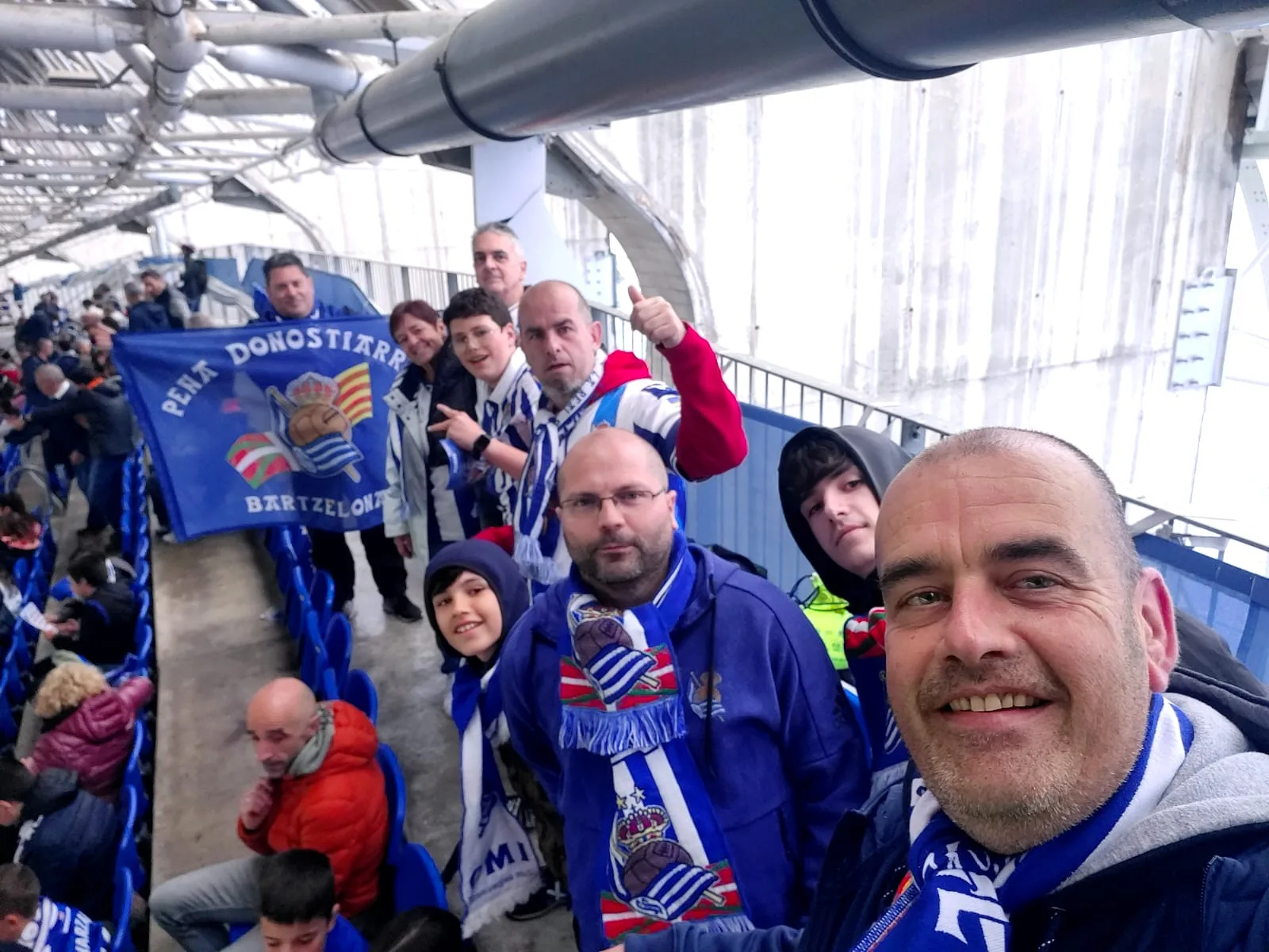 Selfie de grupo en la grada cubierta del Reale Arena con la bandera de la Peña Donostiarras Bartzelona