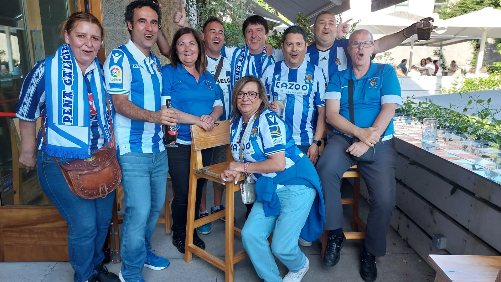 Socios con bufanda de la Peña Galicia en una terraza durante el acto de hermanamiento