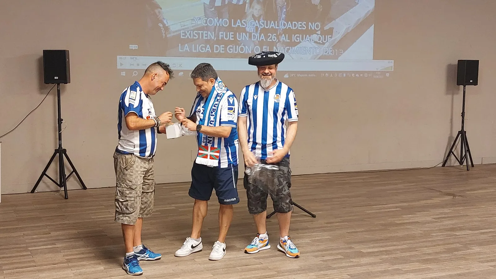 Socios en un escenario recibiendo un obsequio conmemorativo durante el aniversario de la Peña Galicia Txuri Urdin