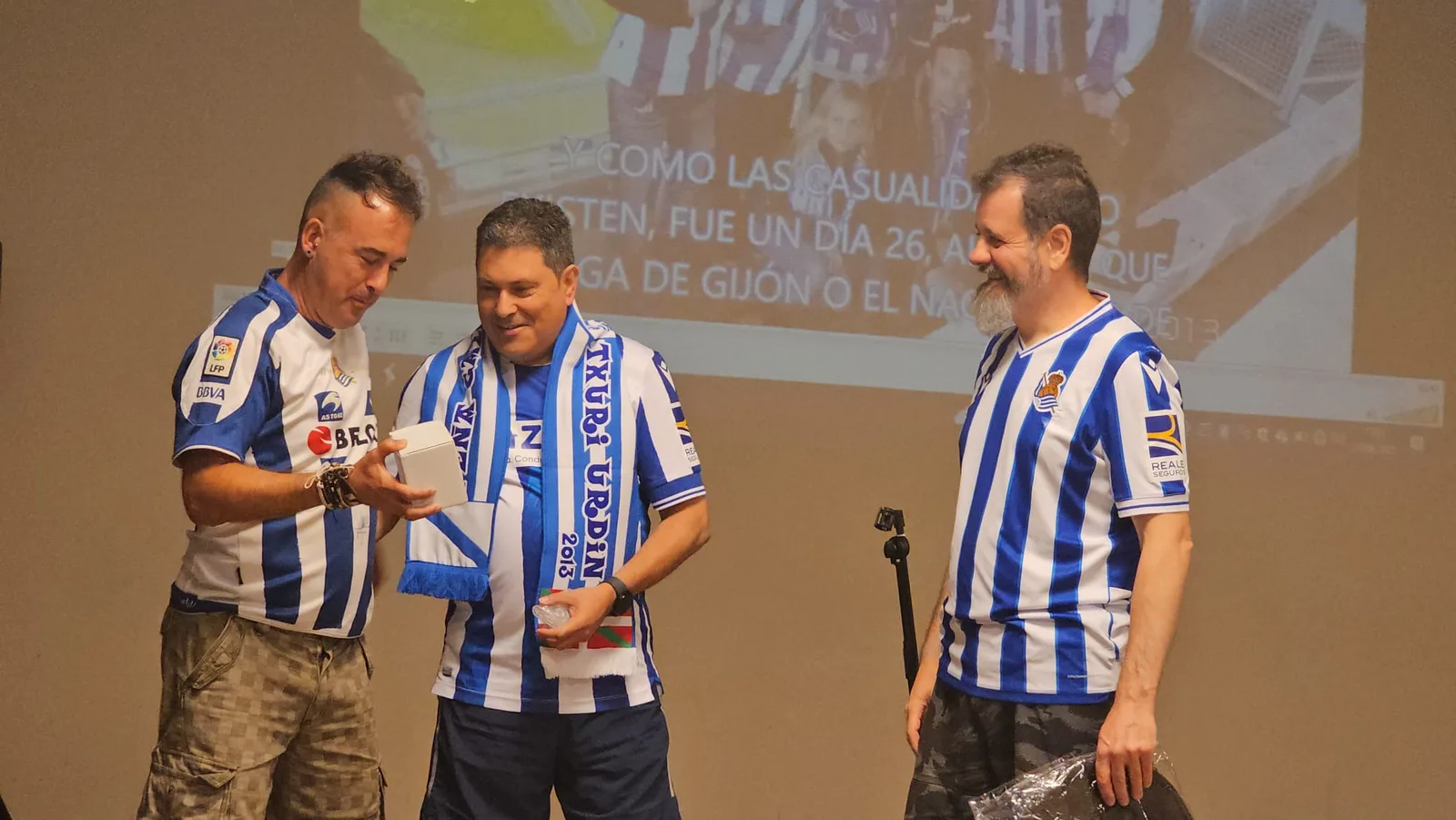 Foto de grupo numeroso de socios con bufandas de la Peña Galicia Txuri Urdin