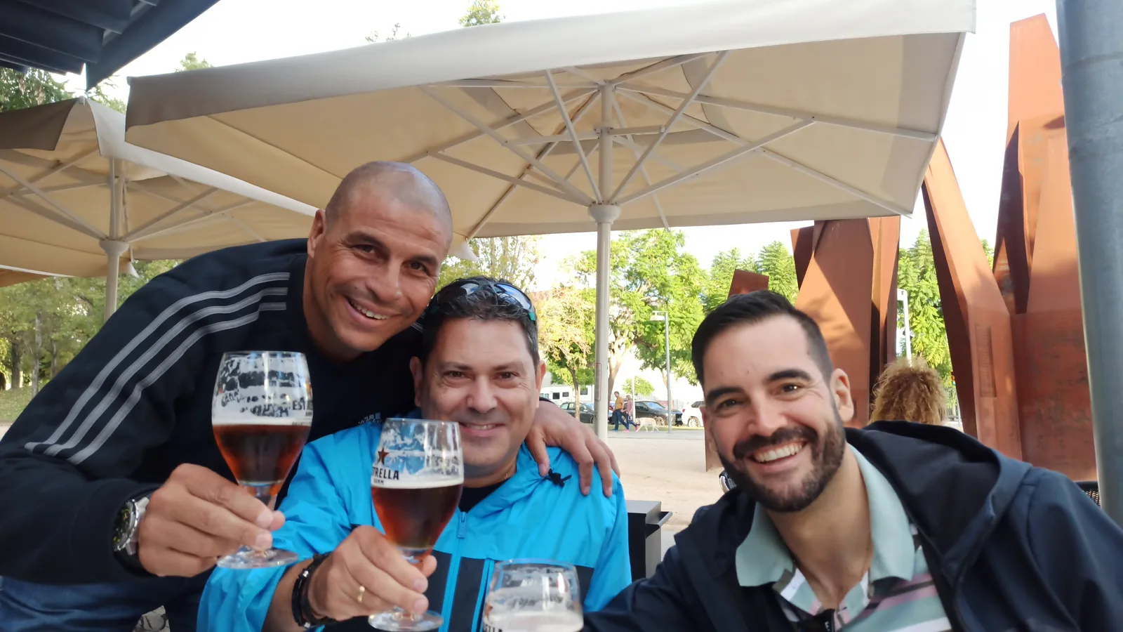 Socios de la peña brindando con cerveza en una terraza de Girona