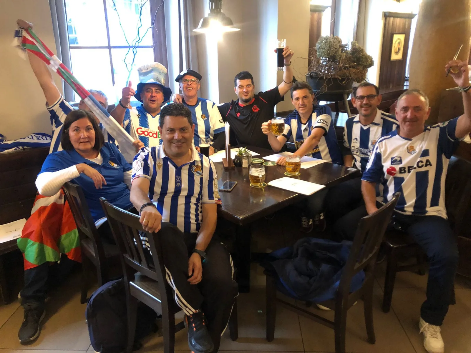 Socios de la peña en un bar de Graz con camisetas de la Real Sociedad y una ikurriña, durante el viaje a la Liga Europa