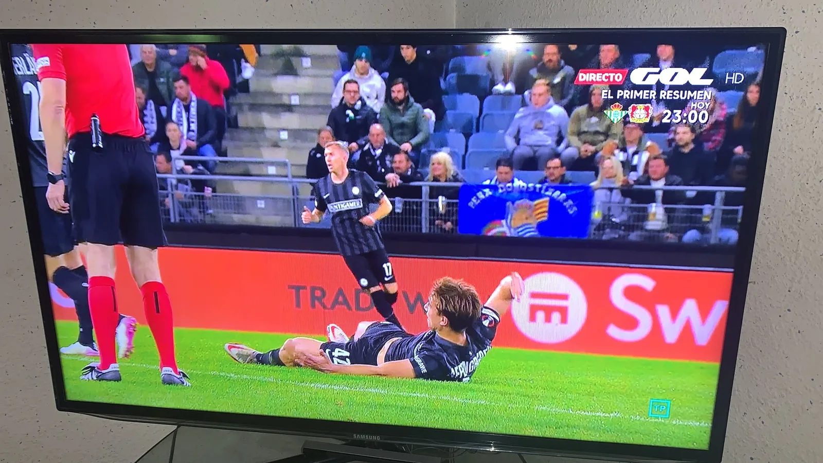 Retransmisión de televisión del partido en Graz con una bufanda de la Peña Donostiarras visible en la grada