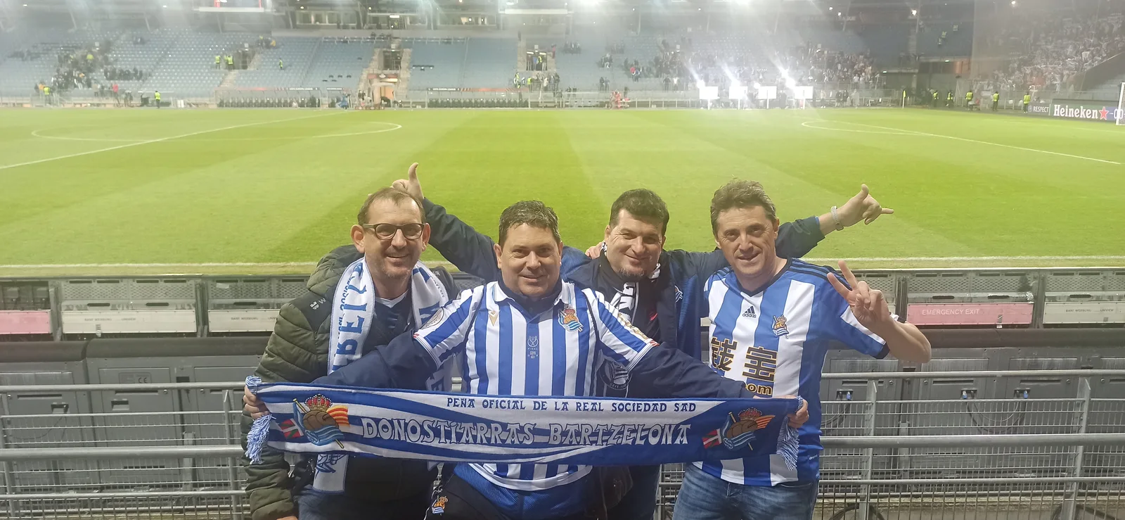 Socios de la peña en las escaleras del estadio de Graz de noche con la bufanda Donostiarras Bartzelona