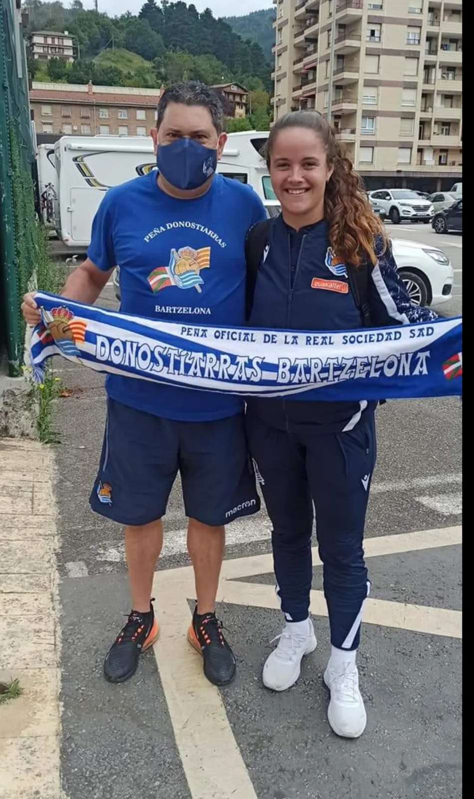 Socio de la peña junto a una jugadora de la Real Sociedad femenina sujetando la bufanda Donostiarras Bartzelona