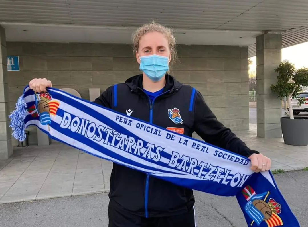 Jugadora de la Real Sociedad femenina sujetando en solitario la bufanda de la Peña Donostiarras Bartzelona