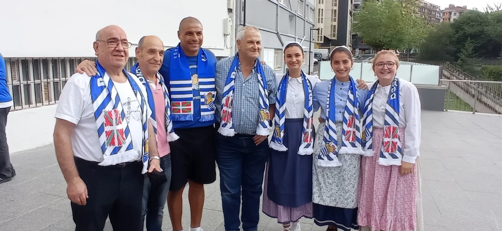Juan Gómez, exjugador argentino de la Real Sociedad, con socios de la peña y jóvenes con traje regional vasco