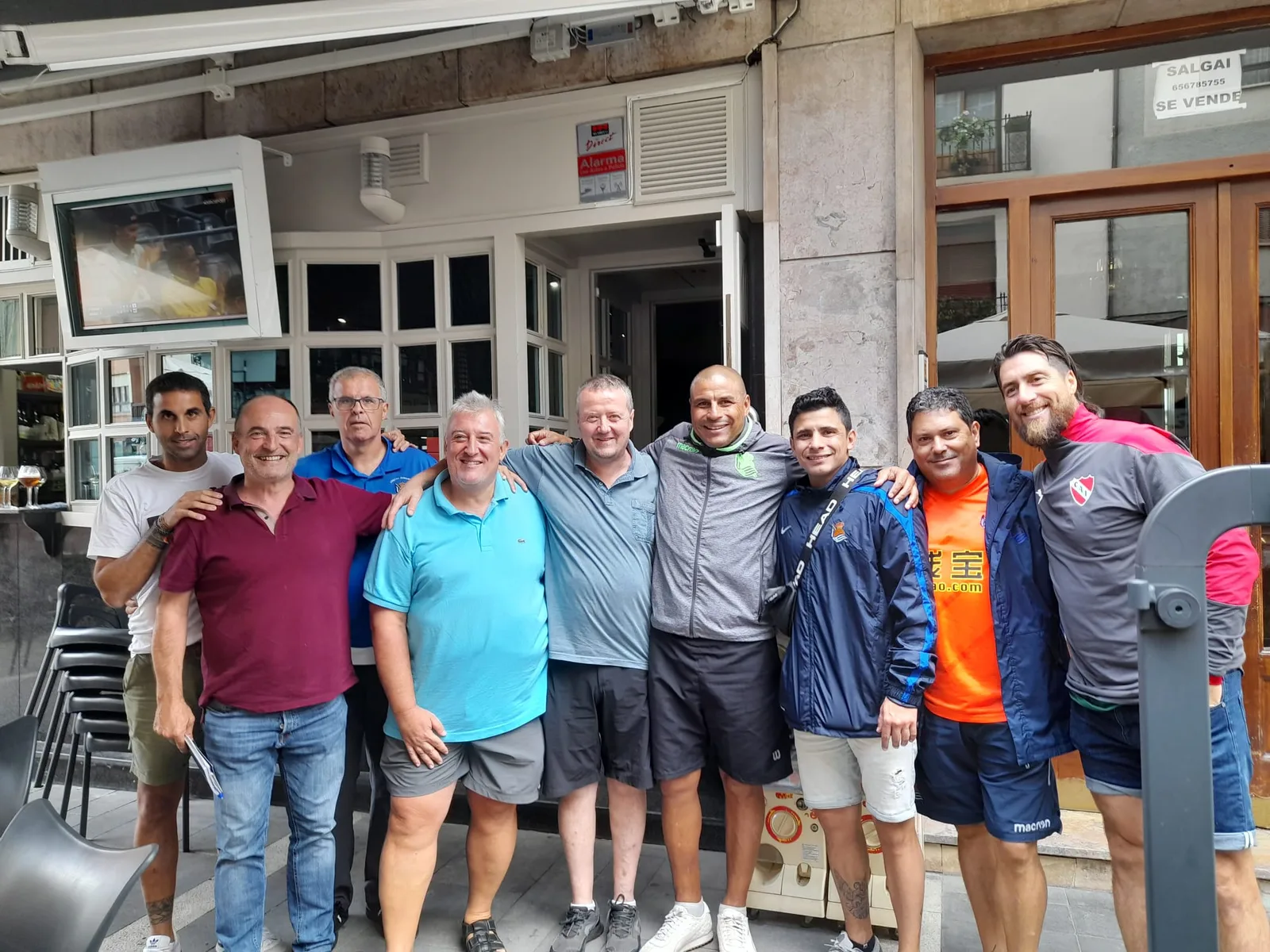 Juan Gómez con un grupo de socios de la peña en la terraza de un bar de noche