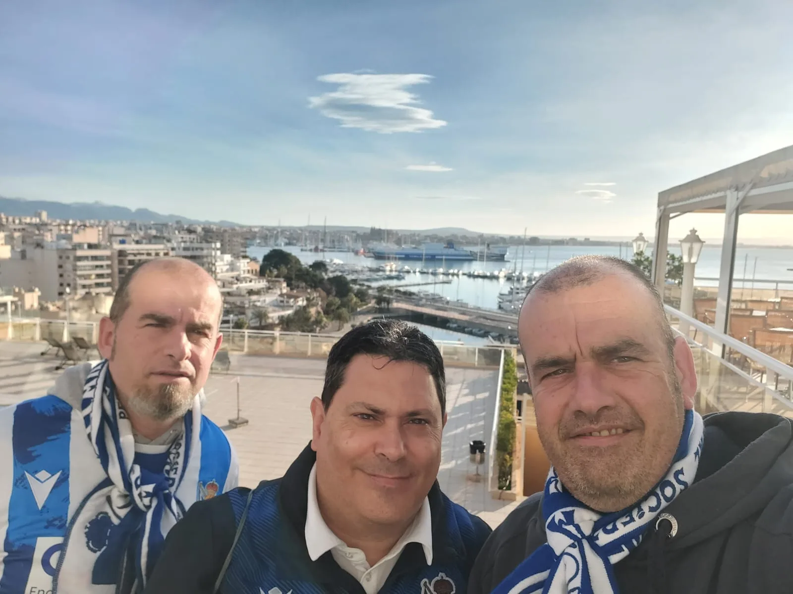 Socios de la peña con bufanda y vistas panorámicas del puerto de Palma de Mallorca