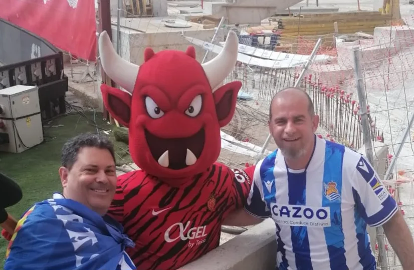 Socios de la peña junto a la mascota del Real Mallorca en una zona en obras del estadio de Son Moix