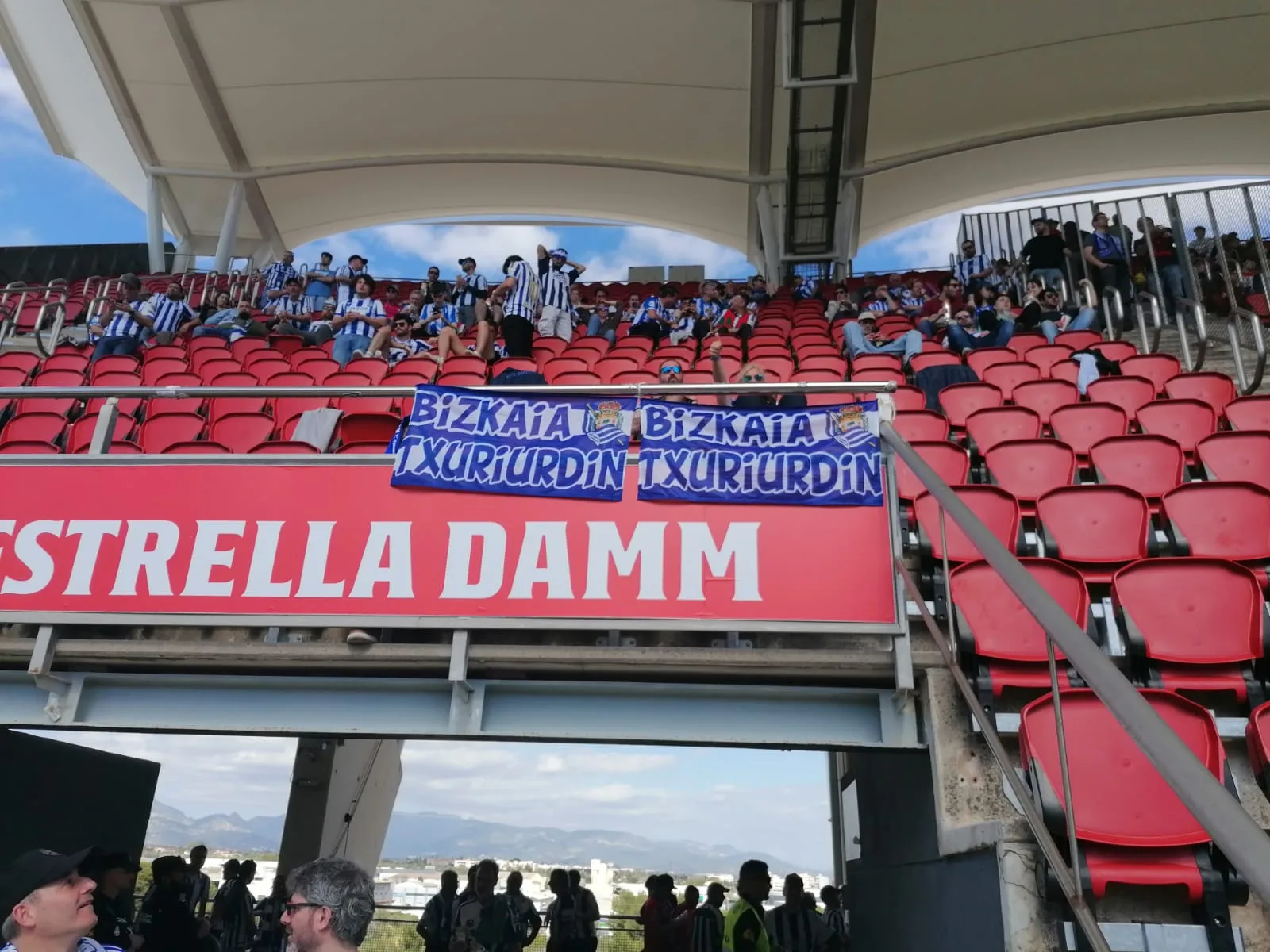 Grada del estadio de Son Moix con aficionados de la Real Sociedad y bufandas de la Peña Bizkaia Txuriurdin