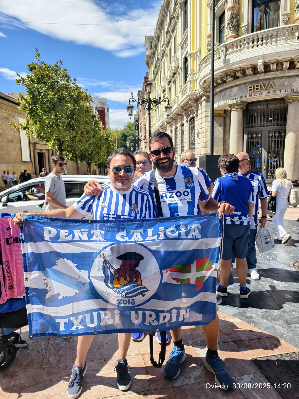 Socios con la bandera de la Peña Galicia Txuri Urdin en otra calle histórica de Oviedo