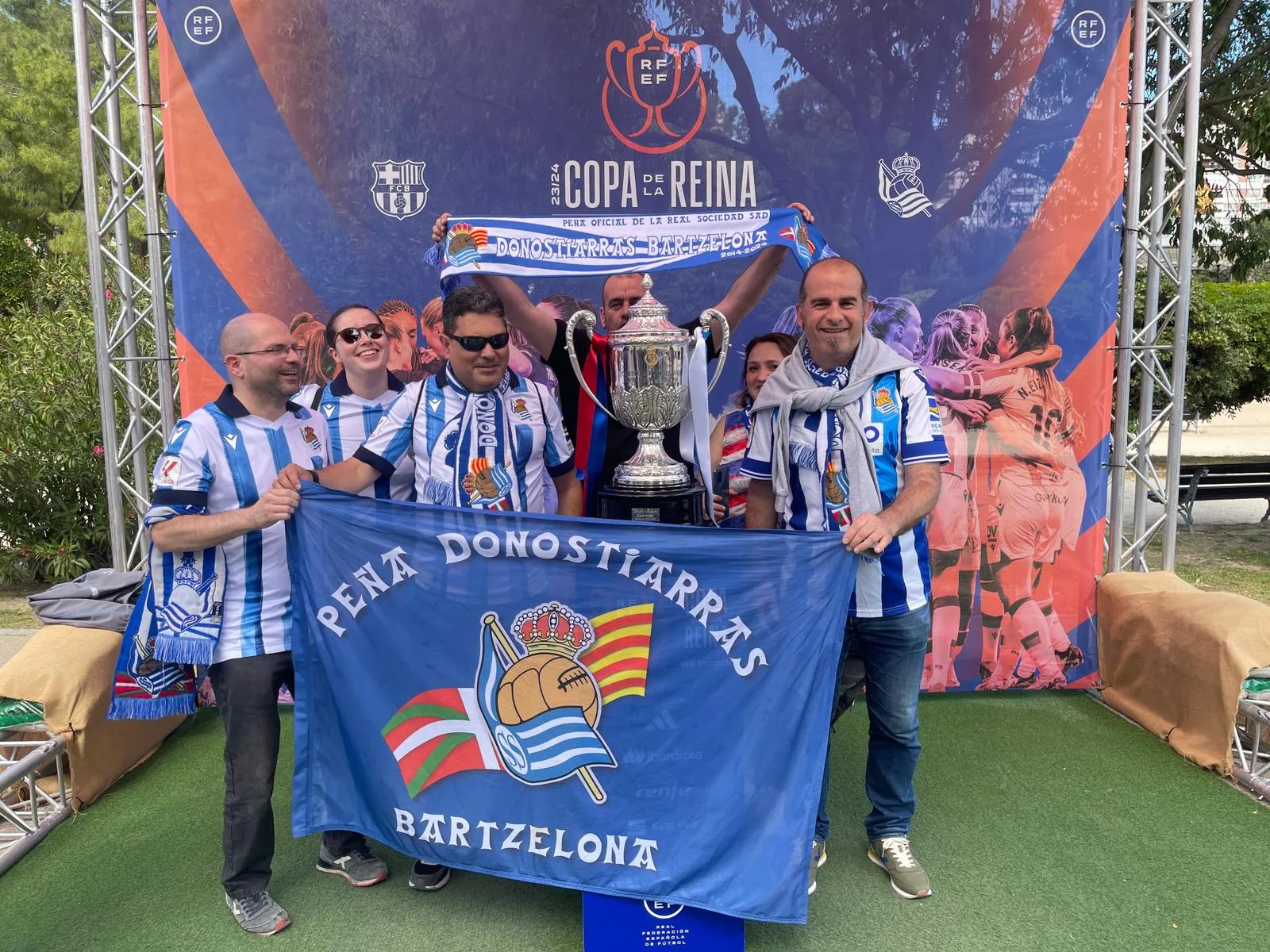 Socios con la bandera de la peña y el trofeo en el photocall oficial de la Copa de la Reina 2023/24